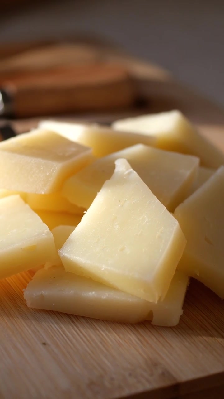 Primo piano di formaggio a fette su un tagliere di legno