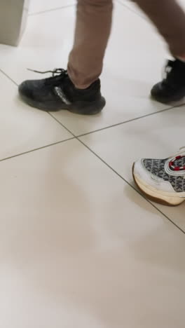 cámara que muestra la mitad inferior de varias personas entrando en un ascensor. la escena captura el movimiento y la variedad de zapatos a medida que las personas entran en el ascensor