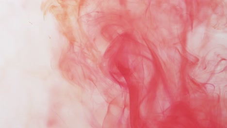 Slow-motion-video-of-pink-watercolor-ink-mixing-in-water-against-grey-background