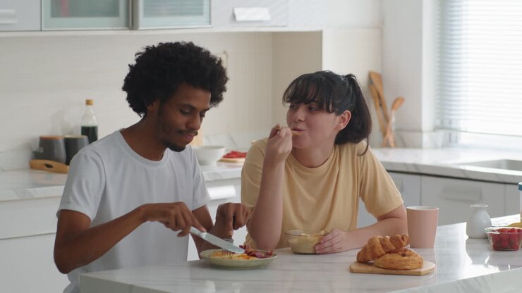 Bi-ethnic Married Couple Having Breakfast at Home Kitchen