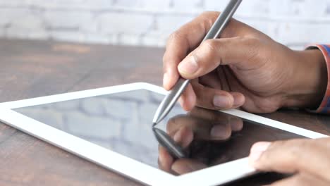 person using a digital pen on a tablet