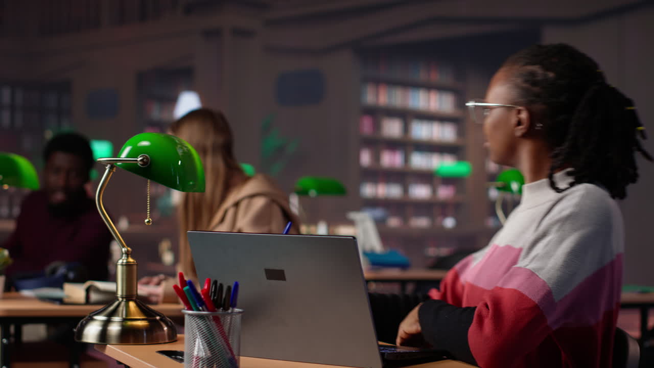 Young scholar focuses on exam preparations in the campus library with colleague