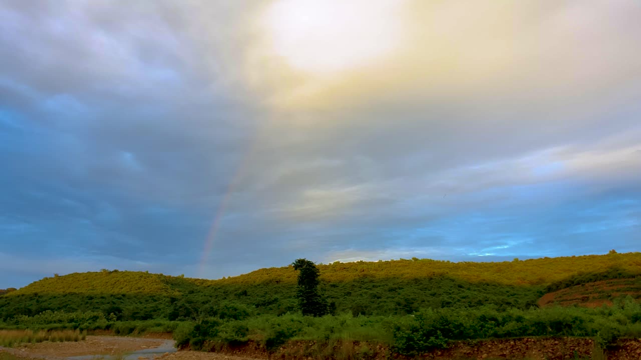 vista impresionante de la madre naturaleza que muestra el arco iris detrás de las montañas en el cielo nublado