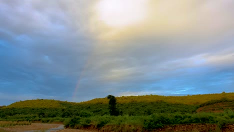 Breathtaking-view-of-mother-nature-showing-rainbow-behind-mountains-in-cloudy-sky