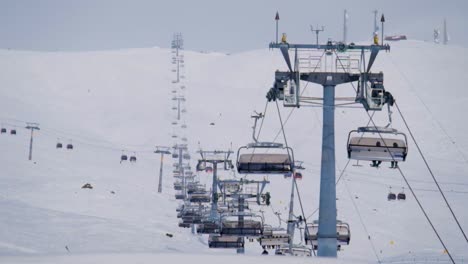 long 6 person ski lift with a cable car intersection during a winter morning in gudauri ski resort, georgia