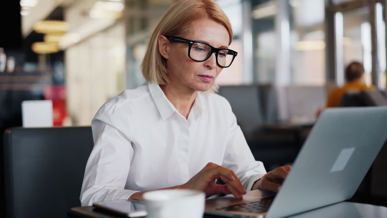 Forretningskvinne som jobber på laptop på kafé