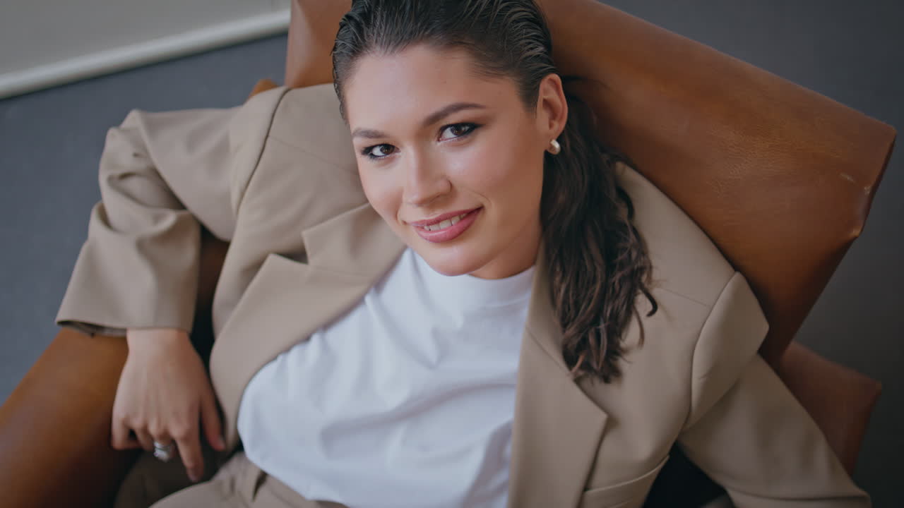 mujer jefe feliz posando en una oficina moderna en un traje de lujo de primer plano.