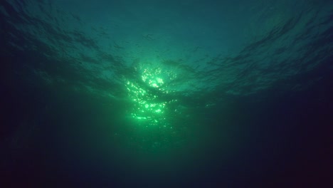 Rolling-waves-and-water-surface-shot-in-slow-motion-from-underwater-agains-the-light-in-a-tropical-ocean-environment