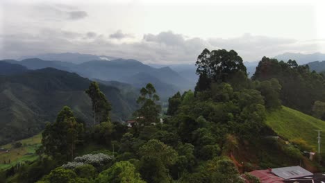 Fly-over-of-colorful-mountain-homes-above-green-valley