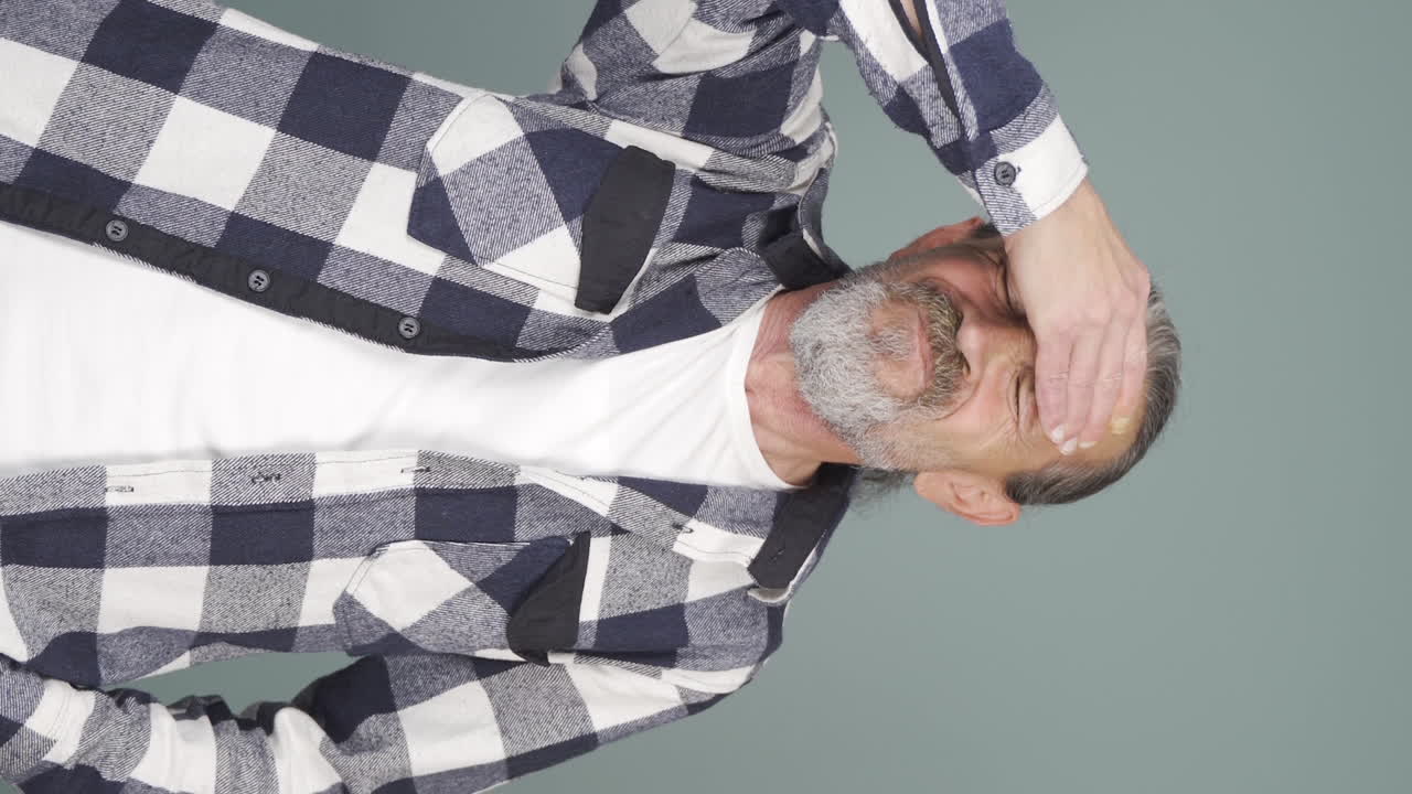 편두통을  ⁇ 고 있는 노인의 수직 비디오가 통증을 경험하고 있습니다.