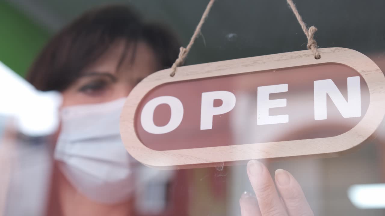 Sad adult woman with face mask closing her small business for corona virus pandemic. 4k 60fps