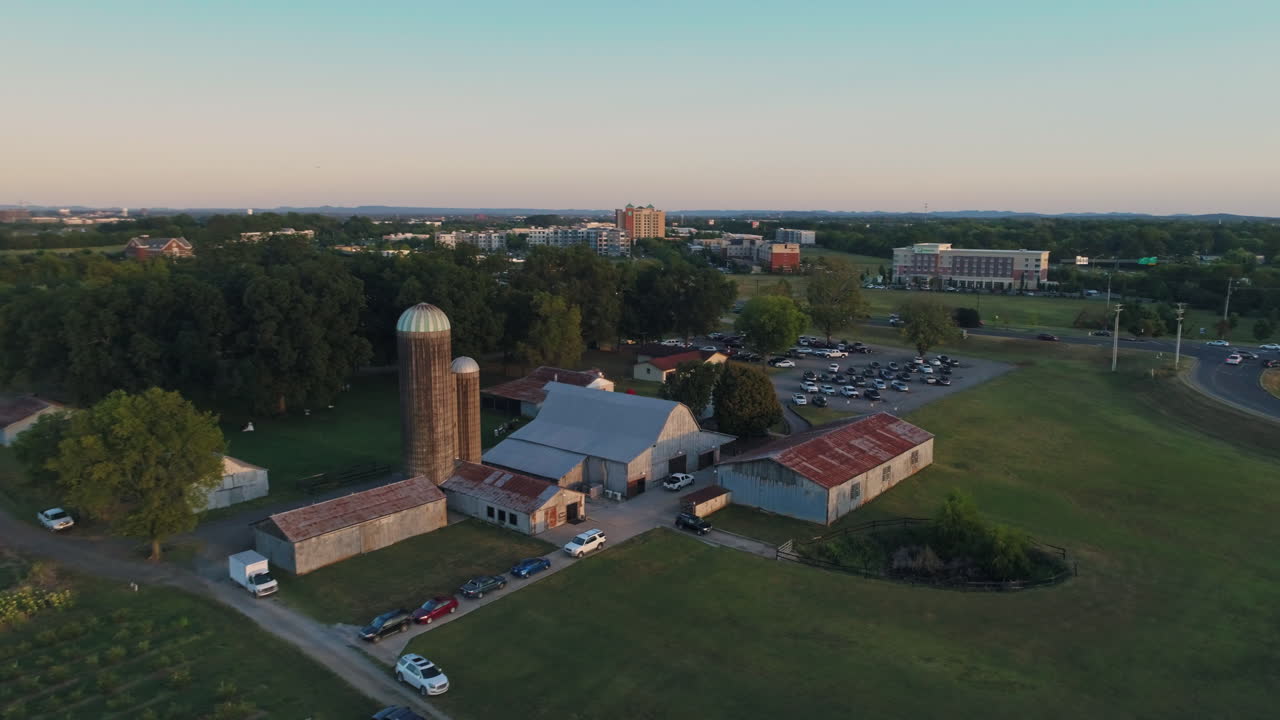 vista aérea granero en órbita con silos de grano con edificios en el fondo, 4k