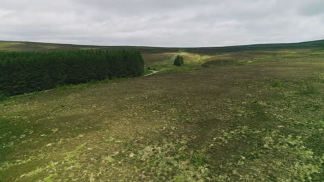 Der-Aufsteigende-Rückfahrwagen-Gibt-Den-Blick-Auf-Die-Bergstraße-Frei,-Auf-Der-Das-Sonnenlicht-Durch-Windgepeitschte-Wolken-Scheint