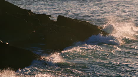 splashing water washing mountain at morning closeup. ocean crashing at sunrise