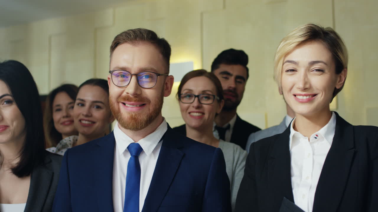 공식적인 옷을 입고 큰 회의에서 웃는 다민족 기업인 그룹의 클로즈업 보기