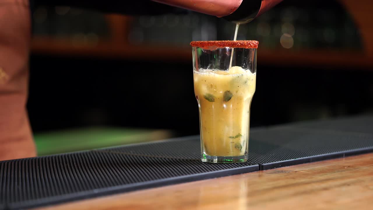 Pineapple drink mojito margarita pi&ntilde;a colada daikiri serving on glass from mixer at mexican latin restaurant bar cantina