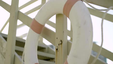 Tilt-up-to-lifeguard-buoy---life-saving-floating-buoyant-hanging-on-station-stairs