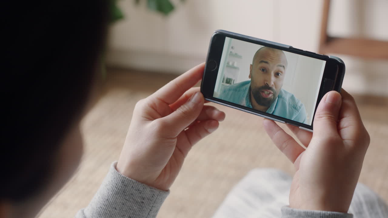 mujer joven teniendo video chat usando smartphone en casa hablando con su novio mostrando su peinado compartiendo estilo de vida disfrutando de una relación a larga distancia