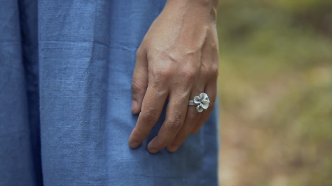 Anel de flor prateado na mão de uma jovem noiva