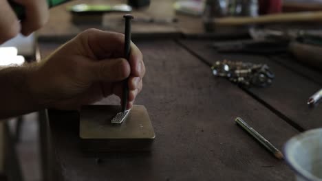 Jeweler-hand-shaping-and-designing-a-silver-ring,-close-up