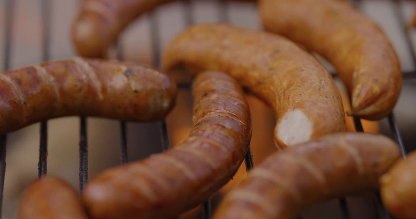 Leckere, brutzelnde Würstchen auf einem Außengrill