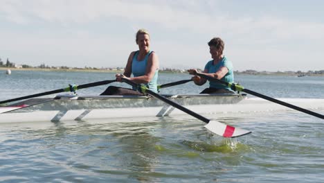 Two-senior-caucasian-women-rowing-boat-on-a-river