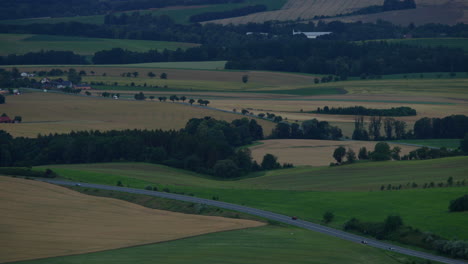 zoomed out on the landscape in the valley where the roads on which cars pass during sunset lead