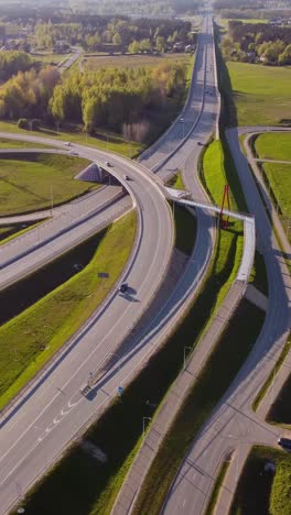 vertical view of access road and distant highway near katlakalns roundabout in latvia. aerial shot