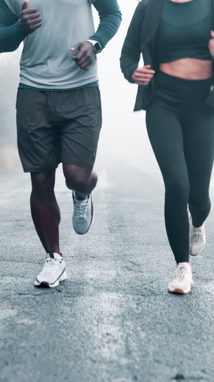 Athletic Couple Running Together on a Misty Road