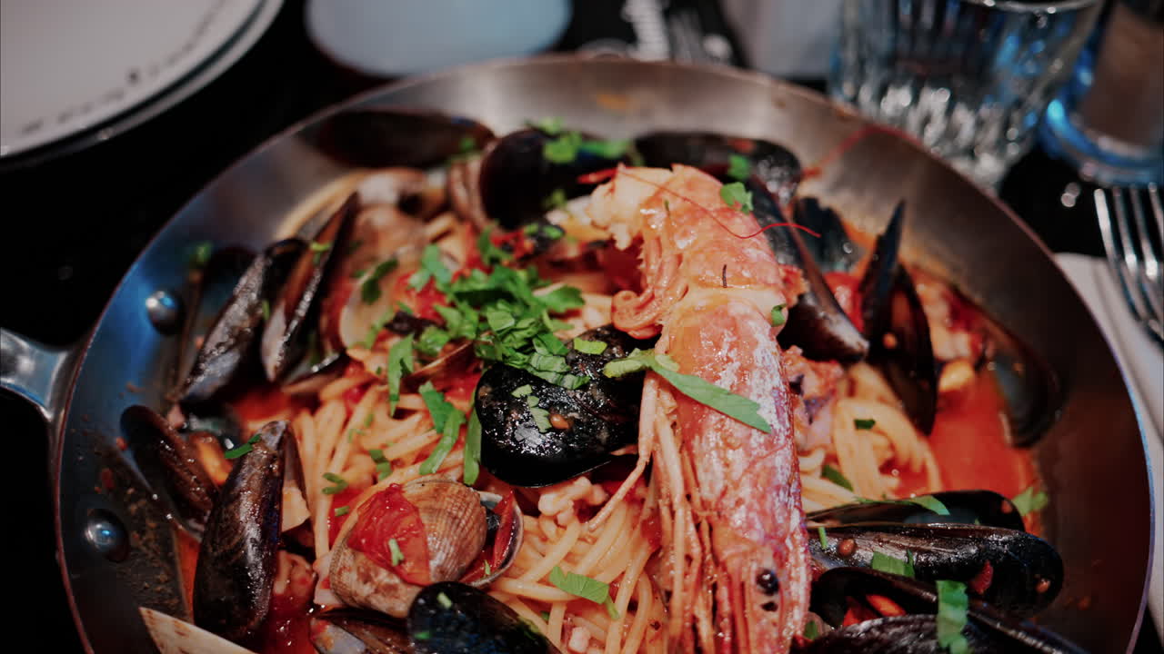 Close up of pasta with tomato sauce and mussels in a pan