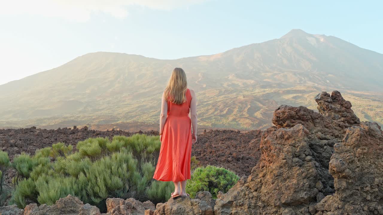 Woman in orange dress amid Teide's vast volcanic landscape, Tenerife