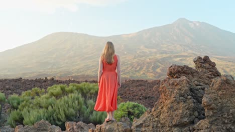 Frau-In-Orangefarbenem-Kleid-Inmitten-Der-Weiten-Vulkanlandschaft-Des-Teide,-Teneriffa