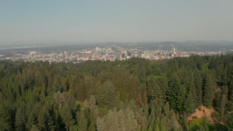 Toma-Aérea-Baja-Sobre-El-Parque-Forestal-Hacia-Portland,-Oregon.