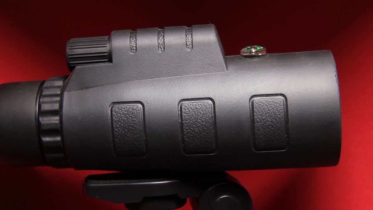 close-up do telescópio de lente de zoom óptico de telefone móvel gigante monocular em fundo vermelho