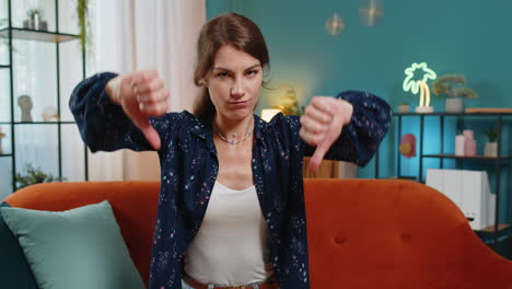 upset unhappy young woman showing thumbs down sign dislike gesture disapproval bad work feedback