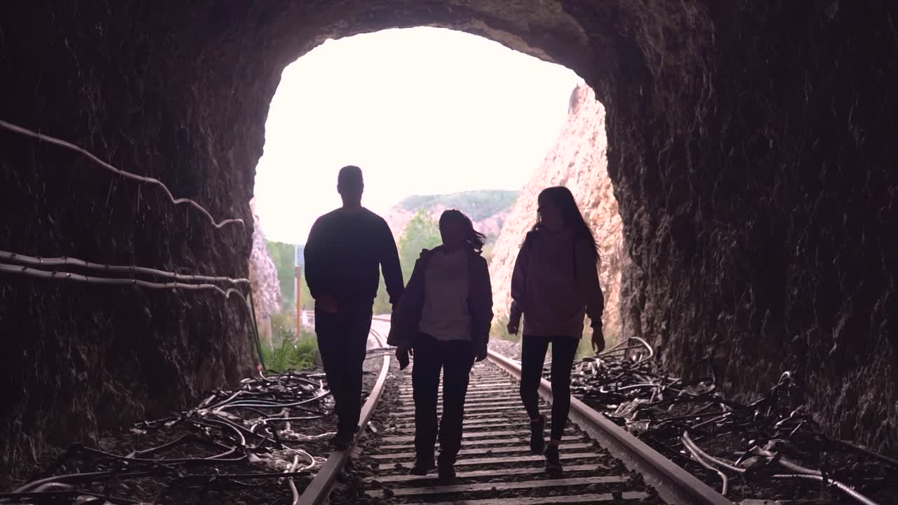 People walking on abandoned railway. Forgotten paths hiker group of backpacker friends. Hiking adventure in nature.