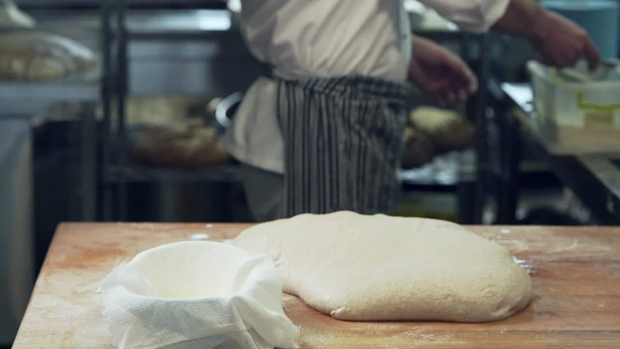 baker sprinkle bread with flour