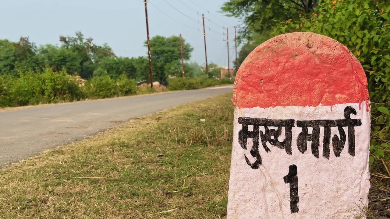 Ripresa con carrellata a sinistra di una pietra miliare che indica "main street no 1" in hindi