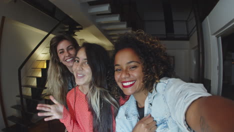 Happy-women-taking-selfie-and-looking-at-phones-camera