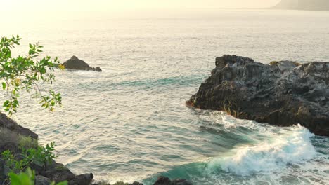 Rollos-De-Olas-En-La-Bahía-Entre-Majestuosas-Formaciones-Rocosas,-Suave-Luz-Nocturna