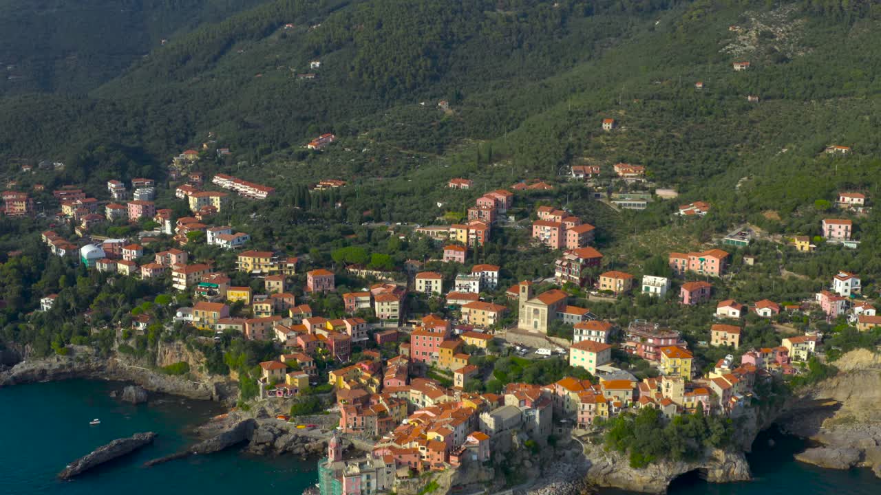 Wide, aerial, tilt-up, reveal shot of colorful, coastalvillage of Tellaro, italy
