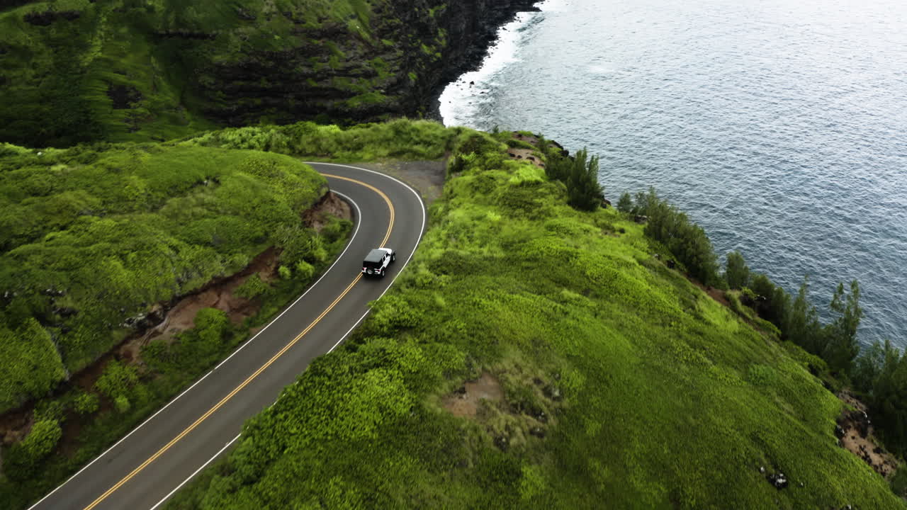 Jeep Drives Around Bend In Maui Mountain Road, Cliff And Ocean Below.