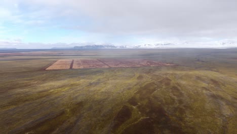 Toma-Aérea-Del-Vasto-Y-Colorido-Terreno-De-Islandia-Con-Campos-De-Mosaico-Bajo-Un-Cielo-Nublado,-Mostrando-La-Paleta-De-La-Naturaleza