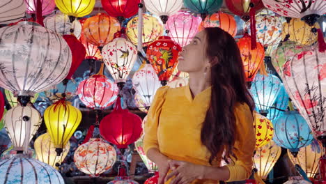 Beautiful-Vietnamese-woman-in-traditional-yellow-dress-surrounded-by-bright-and-colorful-lanterns