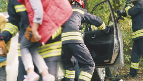firefighters rescuing children from car accident