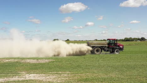 tractor agrícola esparciendo polvo blanco ángulo lateral muy bajo