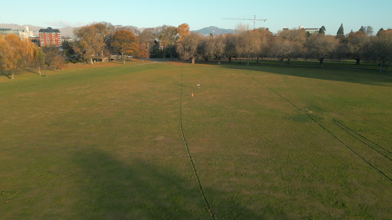 Man Walking Through Hagley Park Christchurch New Zealand High Angle Drone Shot 4K 60FPS