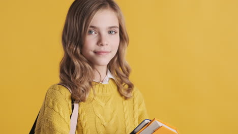 happy teenage caucasian girl student holding notebooks.