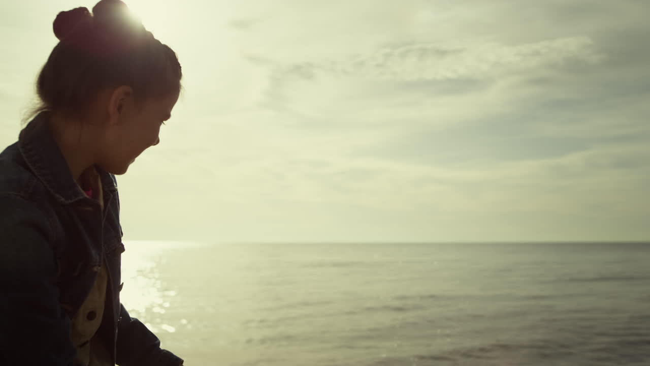 아침 바다에서 해변에서 놀고 있는 흥분된 아이. 어린 소녀는 해안에서 휴가를 즐긴다.