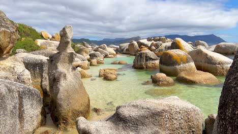 Boulder's-Beach-South-Africa-Simon's-Town-Penguin-Colony-public-swimming-area-Water's-Edge-South-Africa-Netflick-Penguins-Town-early-morning-sunrise-bright-sun-scenic-Cape-Town-slow-motion-pan-right